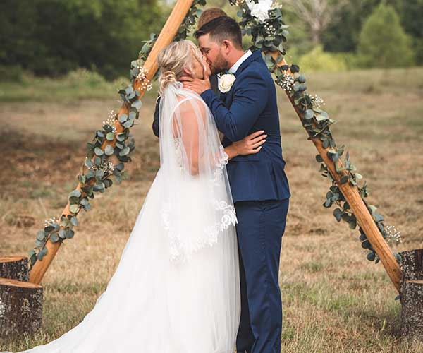 Wedding photo editing after visual bride and groom kissing on grass field during daytime