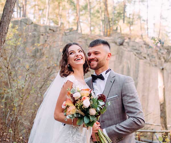 Wedding photo editing after visual man and woman both laughing by tree during daytime