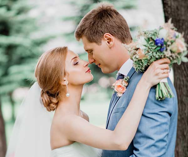 Wedding photo editing after visual man in gray suit kissing woman in white dress