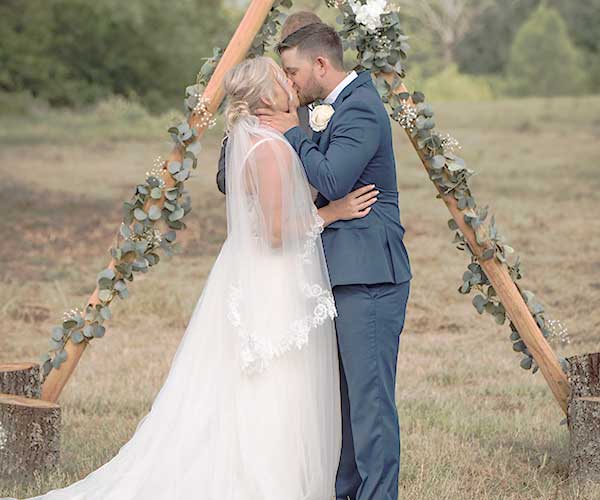 Wedding photo editing before visual bride and groom kissing on grass field during daytime