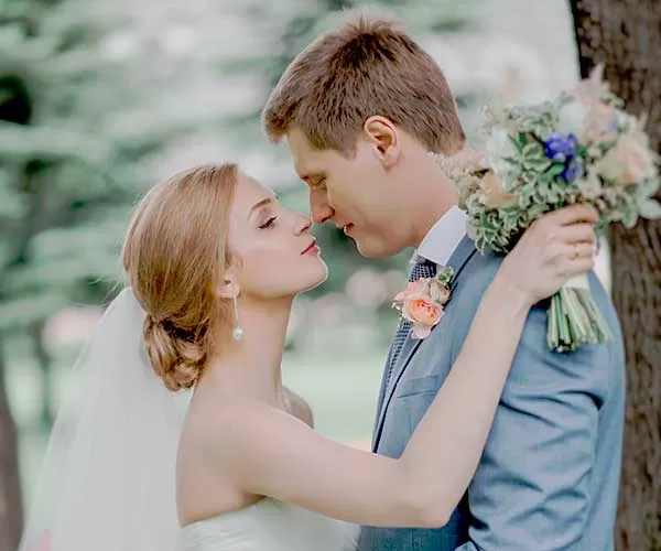 Wedding photo editing before visual man in gray suit kissing woman in white dress